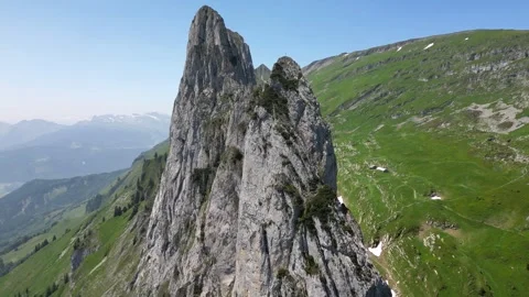 Aerial Cliffside Approach Toward Sharp Rock Peak Saxer Lucke Stock Footage 323331116