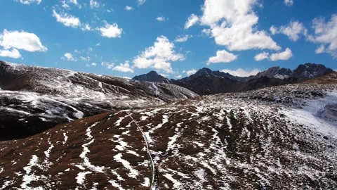 Aerial climbing over a rounded snowy Tibetan ridge Stock Footage 345882528