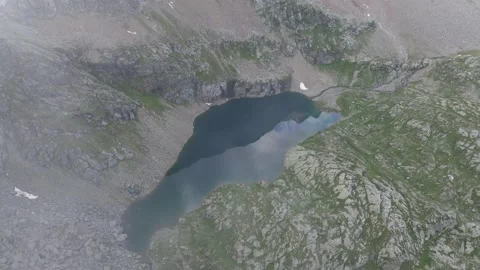 Aerial clip of Alpine lake with clouds reflecting in the water Stock Footage