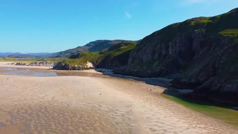 Aerial clip of a beach that features a cliff and some water pools Stock Footage 272604975