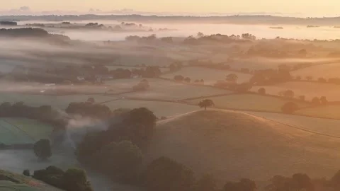 Aerial clip of rolling Devon countryside at dawn on a summer morning, Devon, Stock Footage 283947450