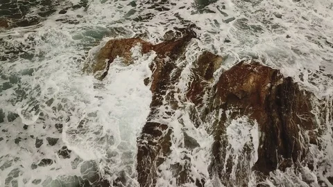 Aerial close approach from above . Waves moving on the rocks. Background Texture Stock Footage 100332141