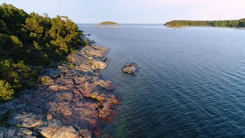 Aerial close up: Drone flying forward and rising in the end at rocky shoreline Stock Footage 78612097