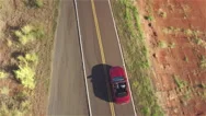 Aerial Close Up: Flying Above Red Convertible Car Driving Along Countryside Road Stock Footage