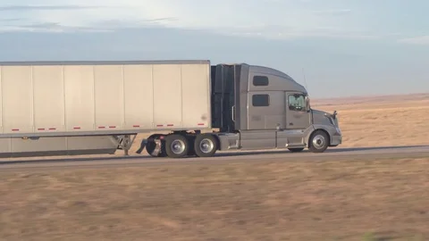 AERIAL, CLOSE UP: Freight container semi truck traveling along the rural highway Stock Footage 76433608