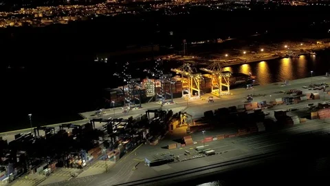 AERIAL, CLOSE UP: Loading containers on large freighter ship in port at night Stock Footage 73754875
