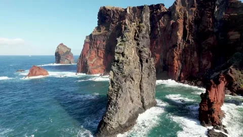 Aerial Close Orbit Triangular Ocean Rock Surrounded by Vibrant Red 動画素材 170398976