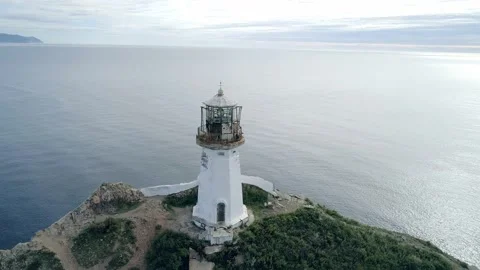 Aerial close-up orbital view of an old lighthouse on the cliff on pacific coast Stock-Footage 168658374