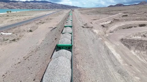 Aerial close up over cargo train with gravel by Orto Tokoy Reservoir in Stock Footage 339156707