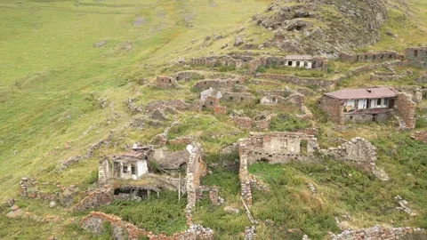 Aerial close up panning view abandoned village of Arsha ruins on hillside. .. Stock-Footage 284239507