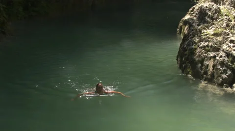 AERIAL, CLOSE UP: Pretty smiling woman swimming in refreshing river on sunny day Stock Footage