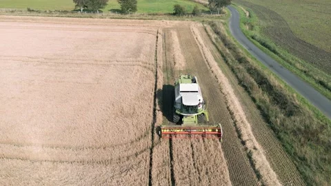 Aerial close up reverse front view tracking clip of a combine harvester Stock Footage 205330696