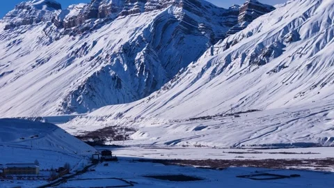 Aerial close-up shot showcasing the dramatic contrast of snow-covered mountain Stock Footage 304945302
