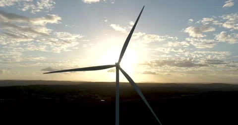Aerial close-up shot of windmills in sunset rotating by the force of the Stock Footage 160945309