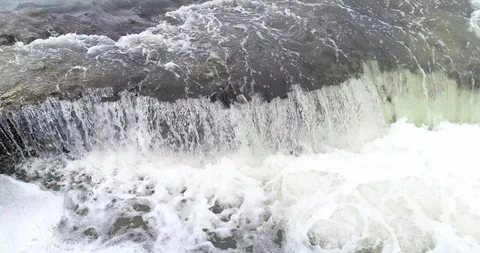 Aerial close up of small stream water fall pooloing and swirling slow motion 库存影片 102533383