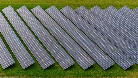 Aerial Close-Up of Solar Panel Rows on Green Energy Farm Foto stock