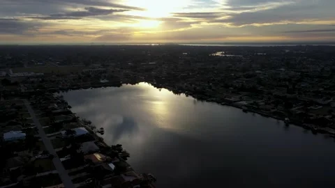 Aerial close sweep  private Cape Coral lake during sunrise Stock Footage 156477902