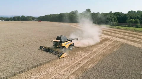 Aerial close up tracking view clip of a combine harvester harvesting wheat Stock Footage 205330414