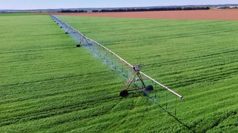 Aerial close view of center pivot irrigation system watering green field Видео 333643337