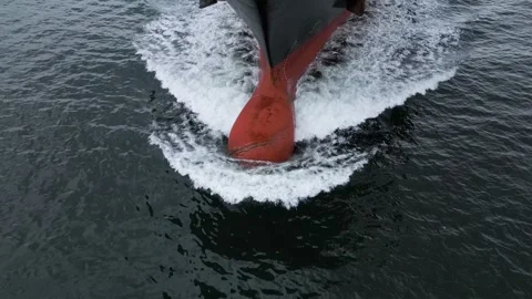 Aerial close-up view of a large cargo ship cutting through the sea, creating Stock Footage 319747317