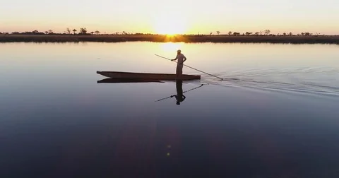 Aerial close-up view of one poler rowing a Mokoro on the waterways of the Stock Footage 78210897