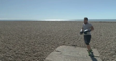 Aerial close up view of a professional boxer training on a beach Stock Footage