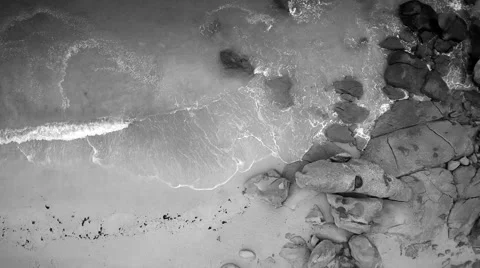 Aerial closeup. Hovering the beach until a granite rock protrusion. Stock Footage 67658755