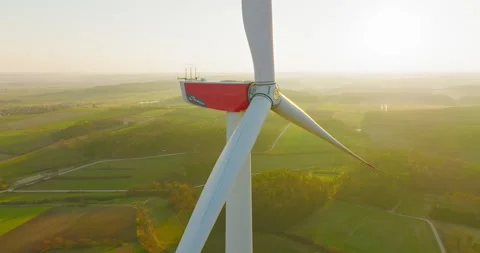 Aerial closeup orbit around windpower at misty golden hour, 4k dci Stock Footage