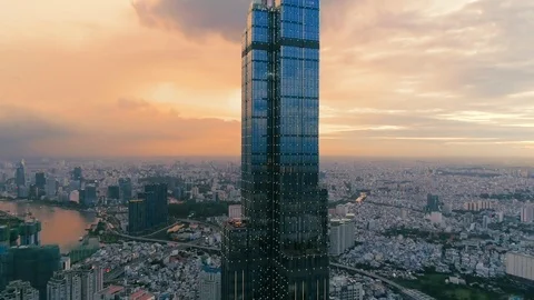 Aerial: Closeup of skyscraper with reflections of sunset then camera reveals all Stock Footage 111820937