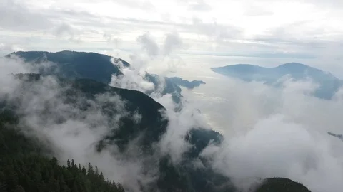 Aerial in the clouds with mountains and ocean Vídeo Stock 90680144