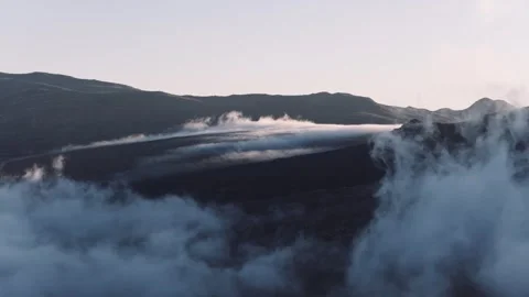 Aerial Clouds Passing Over a Mountain at Sunrise, Medium Close Up Pan Right Stock Footage 337969577