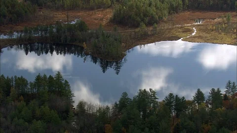 Aerial of clouds reflecting in the river in forest, Lake as we transition across Stock Footage 109137738