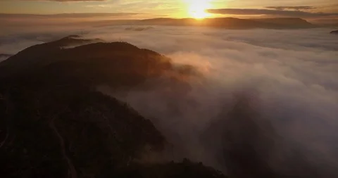 AERIAL - Clouds sea at sunrise over mountains Stock Footage