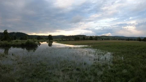 AERIAL Cloudy sky reflecting on the surface of the flooded valley at sunset Stock Footage 109345007