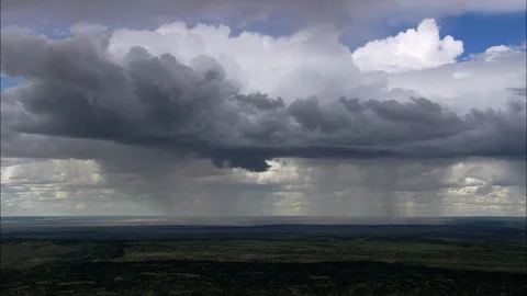 Aerial of cluster of white cloud over the green landscape, Clouds releasing rain Stock Footage 109121045
