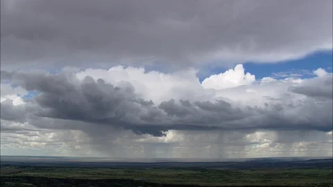 Aerial of cluster of white cloud over the green landscape, Clouds releasing rain Stock Footage 109121116