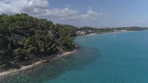 Aerial. Coastline with trees on rocks. Next to a beach of Kallithea, Greece. 4K Stock Footage 116983555