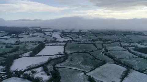 Aerial of cold wintry white and green fields. Amazing patterns, and a wall Stock Footage 102168542