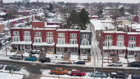 Aerial of colorful row houses covered in snow, decorated for holidays. Stock Footage