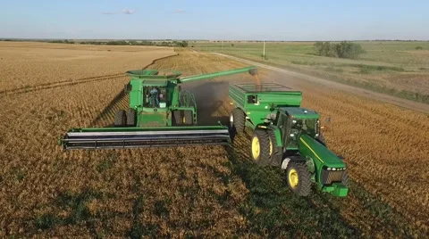 Aerial of Combine Unloading Wheat into Grain Cart Vídeo Stock 60063394