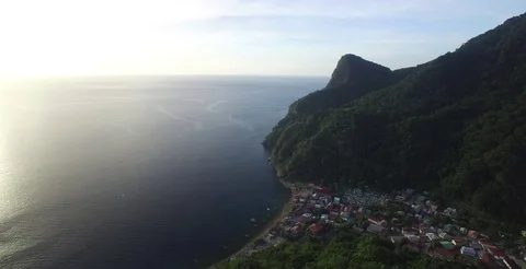 Aerial coming over and down the mountain into the coastal town of Soufriere Vidéo 69955154