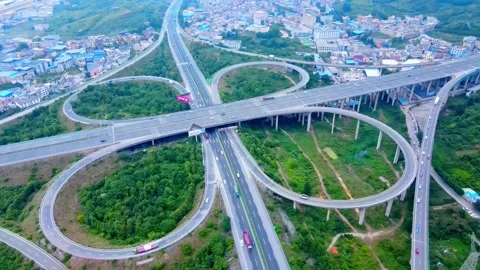 Aerial complex highway interchange with traffic flow in mountainous landscape Video stock 342303369