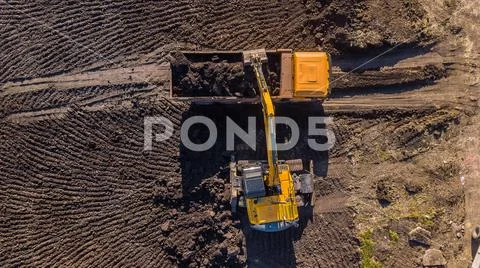 Aerial construction - top down view of an excavator and truck working on a Stock Photos