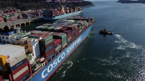 Aerial: Container ship closeup shot of ship and tugs departing from terminal Stock Footage 149781935