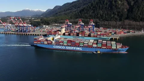 Aerial: Container Ship passing by another container ship at dock Stock Footage 149782195