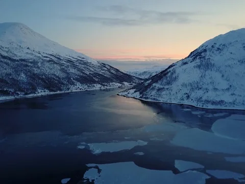 Aerial crane shot at dusk flying over frozen ice in Norway Fjord Stock Footage