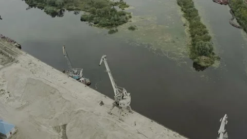 Aerial cranes for loading sand. Delivery of fossil minerals by river water way Stock Footage 136625684