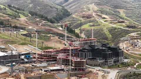 Aerial of cranes moving in construction zone in Deer Valley Utah mountains Stock Footage 335785147