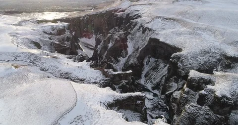 Aerial of deep valley between snow covered rocky mountains in winter Stock Footage 116264386