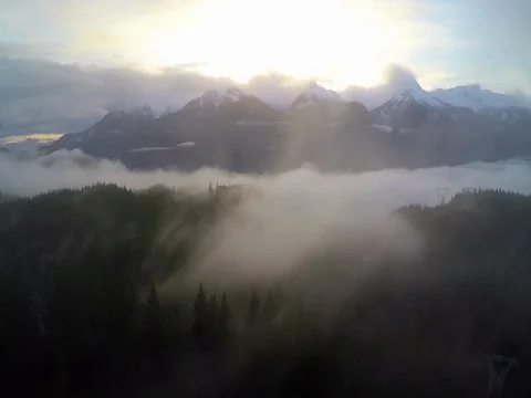 Aerial Golden Sunrise Behind The Snow Covered Forest And Misty